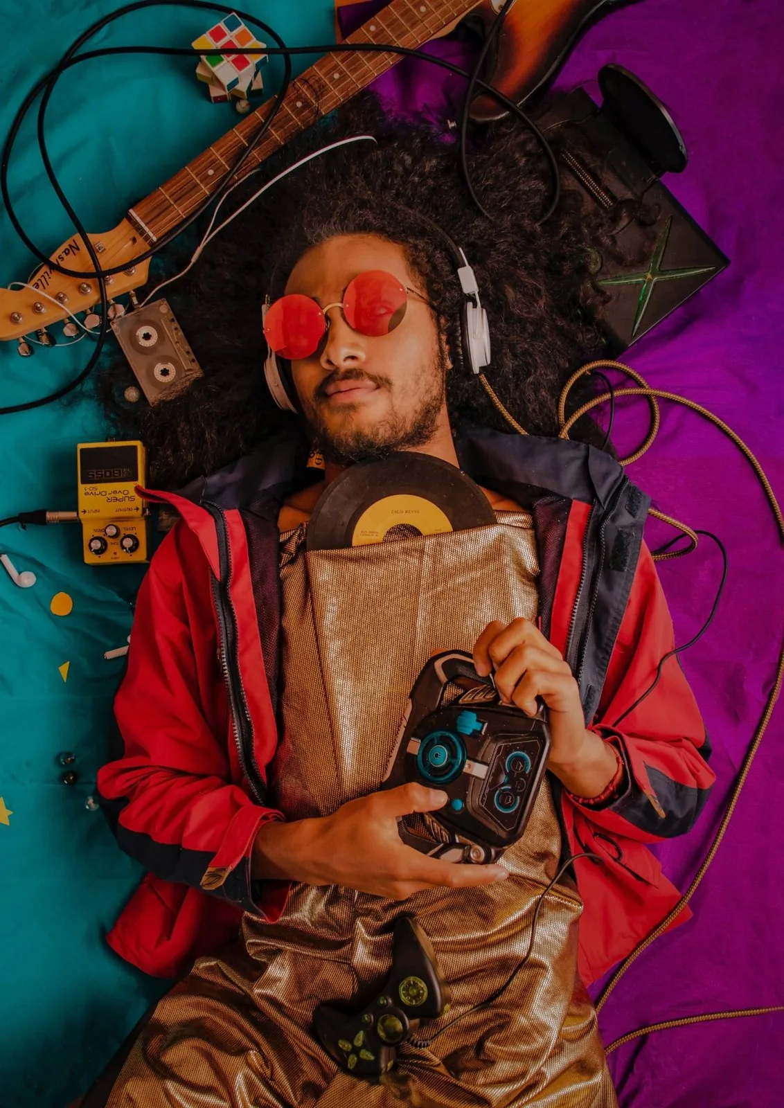 A listener in headphones surrounded by records and instruments